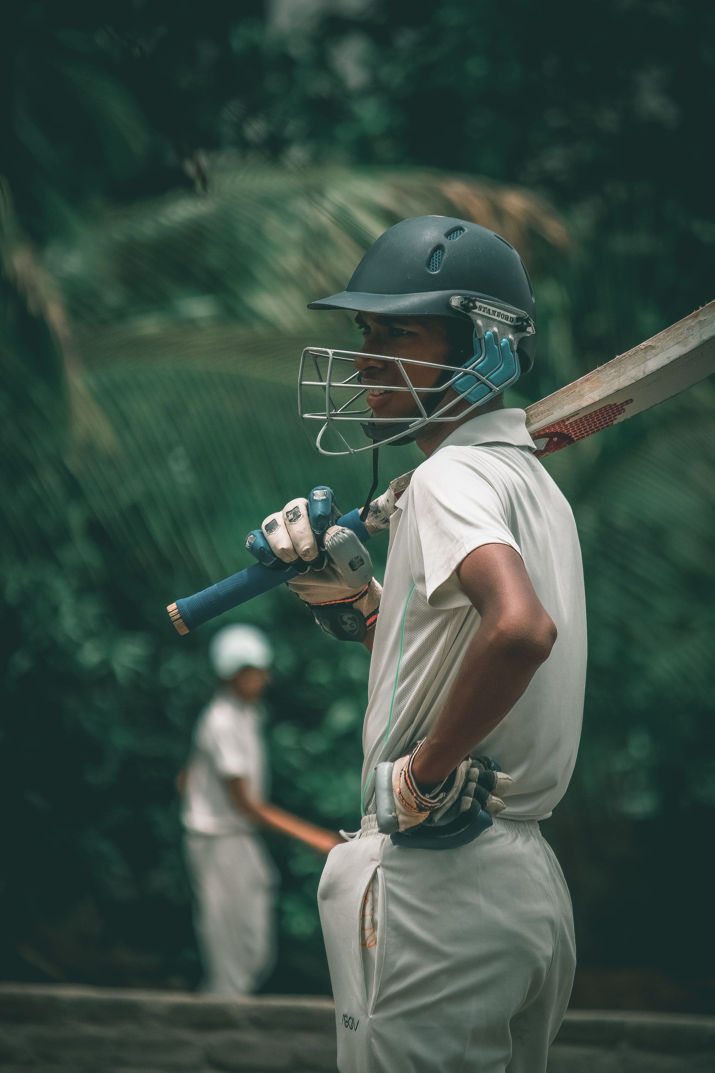 A batsman in whites playing a shot