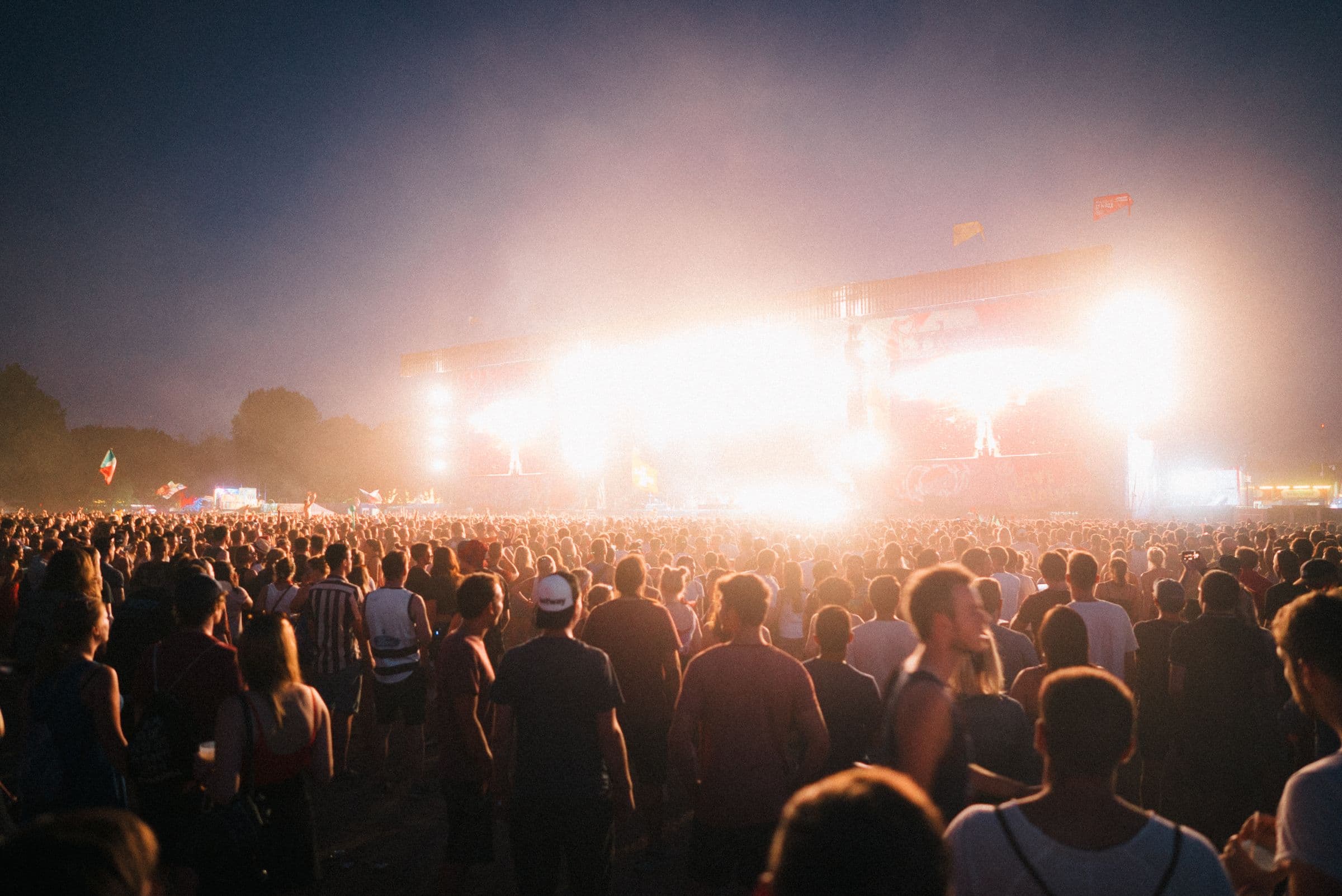 A concert crowd silhouetted against stage lights