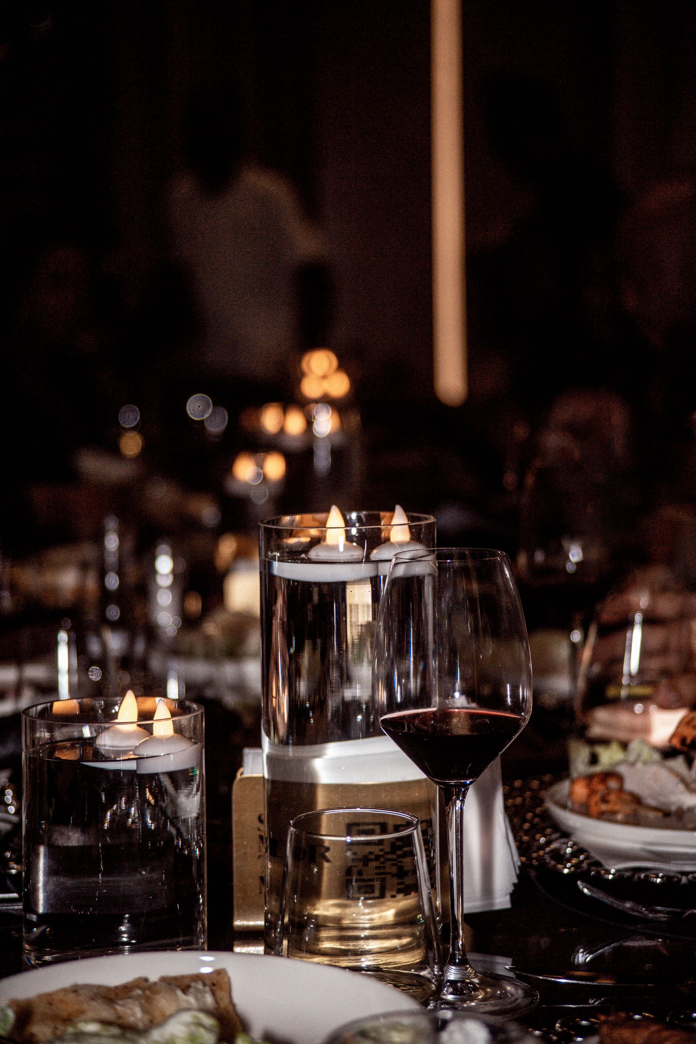 Glassware on a bar in a low-lit lounge before service